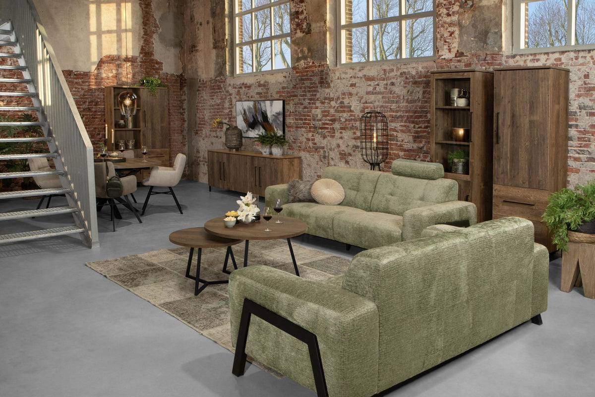 Woonkamer met groene bank en salontafels